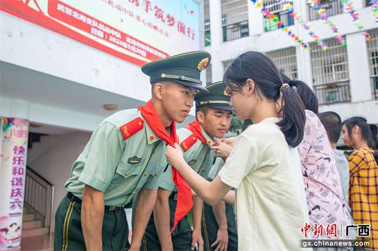 5月28日,特殊教育学校的孩子们为武警官兵们带上红领巾。刘坚 供图 5月28日,特殊教育学校的孩子们为武警官兵们带上红领巾。刘坚 供图