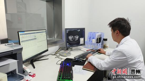 在石阡县花桥镇中心卫生院，医生正在对患者进行CT扫描。蔡庆润  摄
