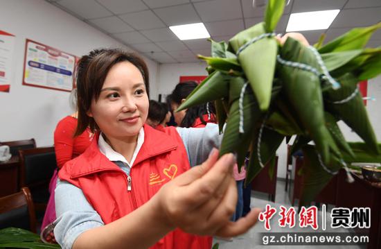 6月6日，贵阳市南明区五里冲街道松园居委会的工作人员正展示包好的粽子。