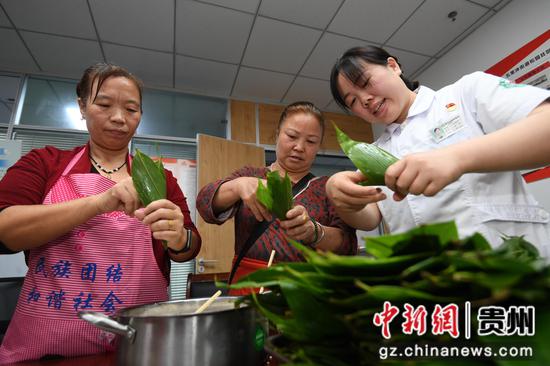 6月6日，贵州省建筑医院的医护人员与贵阳市南明区五里冲街道松园居委会的辖区居民一起包粽子。