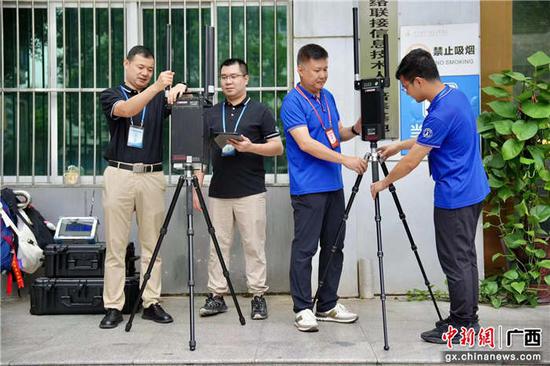 广西壮族自治区无线电监测站保障人员在考点架设无线电侦测设备。