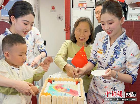 图 乘务组为旅客发放生日蛋糕 图 乘务组为旅客发放生日蛋糕