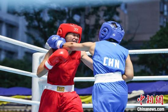 6月16日晚，2024年全国少年(U16)拳击锦标赛-预赛(南半区)在贵州省黔南布依族苗族自治州贵定县乡贤文化广场举行各级别决赛，来自贵州、湖北、重庆、广东、安徽等地的拳击运动员在擂台上展开竞逐。图为贵州运动员张仁靓(蓝衣)和江苏运动员相嫣然在进行女子54-57公斤级决赛。中新社记者 瞿宏伦 摄