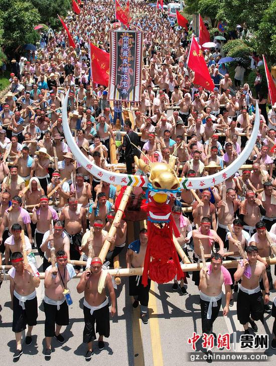 2024年6月15日,在贵州省黔东南苗族侗族自治州施秉县举行的独木龙舟节上,千余名壮汉抬着98.8米长的世界最长独木龙舟进行巡游。磨桂宾 摄 2024年6月15日,在贵州省黔东南苗族侗族自治州施秉县举行的独木龙舟节上,千余名壮汉抬着98.8米长的世界最长独木龙舟进行巡游。磨桂宾 摄