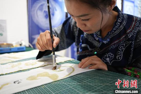 图为6月19日,王秋雨在织金县平远古镇的依文织金数字化展厅制作蜡染。周燕玲 摄 图为6月19日,王秋雨在织金县平远古镇的依文织金数字化展厅制作蜡染。周燕玲 摄