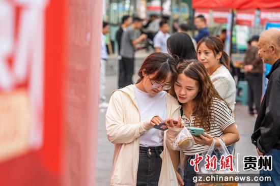 2024年6月19日,市民在贵州省毕节市公园路的街头招聘会现场了解企业招聘信息。 2024年6月19日,市民在贵州省毕节市公园路的街头招聘会现场了解企业招聘信息。