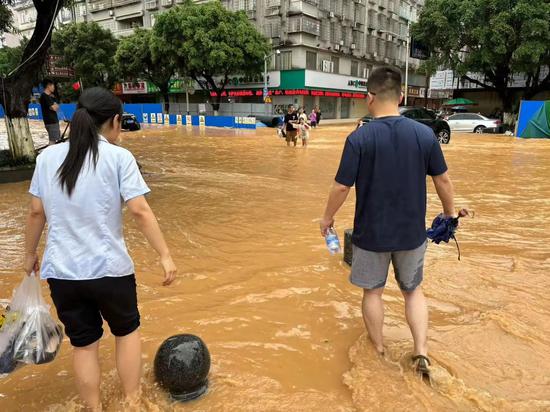 图为农行广西钟山县支行员工正在赶往网点，协助开展防洪救灾工作。
