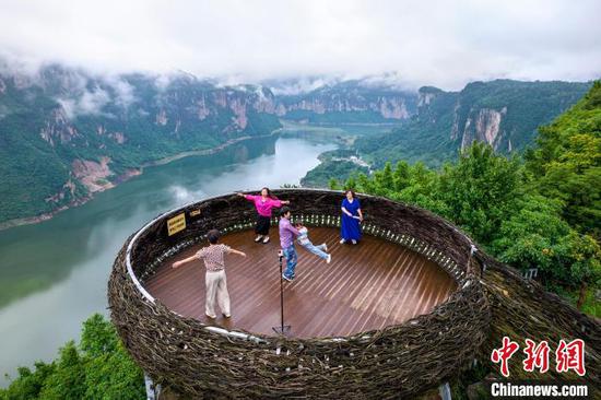 6月20日,贵州省黔西市乌江源百里画廊东风湖景区呈现云雾缭绕的水墨画卷,游客在景区内的花都里化屋野奢度假营地观景拍照。史开心 摄 6月20日,贵州省黔西市乌江源百里画廊东风湖景区呈现云雾缭绕的水墨画卷,游客在景区内的花都里化屋野奢度假营地观景拍照。史开心 摄