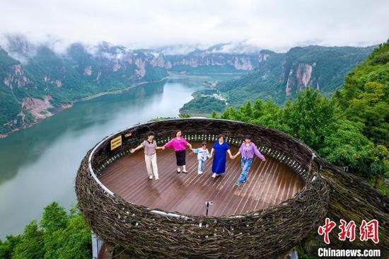 6月20日,贵州省黔西市乌江源百里画廊东风湖景区呈现云雾缭绕的水墨画卷,游客在景区内的花都里化屋野奢度假营地观景拍照。史开心 摄 6月20日,贵州省黔西市乌江源百里画廊东风湖景区呈现云雾缭绕的水墨画卷,游客在景区内的花都里化屋野奢度假营地观景拍照。史开心 摄