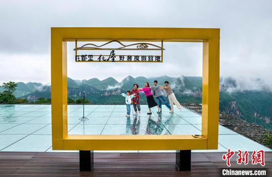 6月20日,贵州省黔西市乌江源百里画廊东风湖景区呈现云雾缭绕的水墨画卷,游客在景区内的花都里化屋野奢度假营地观景拍照。史开心 摄 6月20日,贵州省黔西市乌江源百里画廊东风湖景区呈现云雾缭绕的水墨画卷,游客在景区内的花都里化屋野奢度假营地观景拍照。史开心 摄