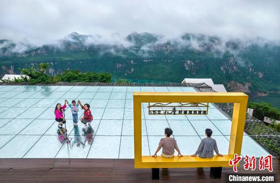 6月20日,贵州省黔西市乌江源百里画廊东风湖景区呈现云雾缭绕的水墨画卷,游客在景区内的花都里化屋野奢度假营地观景拍照。史开心 摄 6月20日,贵州省黔西市乌江源百里画廊东风湖景区呈现云雾缭绕的水墨画卷,游客在景区内的花都里化屋野奢度假营地观景拍照。史开心 摄