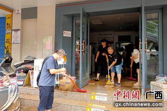 图为员工在洪水退去后清除淤泥，确保尽快恢复正常运营。
