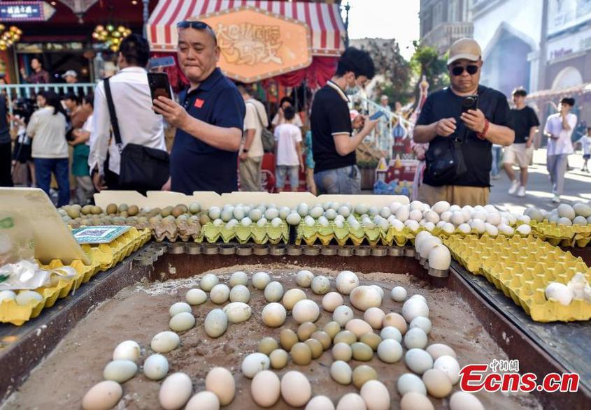 Visitors take photos at the Second Xinjiang Barbecue Festival held at the Grand Bazaar in Urumqi, Northwest China's Xinjiang Uyghur Autonomous Region, June 15, 2024. (Photo: China News Service/Liu Xin)