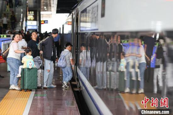 7月11日,小旅客和家人在贵阳北站月台登车。当日正值暑运,位于贵阳市观山湖区的贵阳北站学生和儿童旅客明显增加。据悉,进入暑运以来,贵阳北站客流平稳有序,日均发送旅客9.1万人次。 中新社记者 瞿宏伦 摄 7月11日,小旅客和家人在贵阳北站月台登车。当日正值暑运,位于贵阳市观山湖区的贵阳北站学生和儿童旅客明显增加。据悉,进入暑运以来,贵阳北站客流平稳有序,日均发送旅客9.1万人次。 中新社记者 瞿宏伦 摄