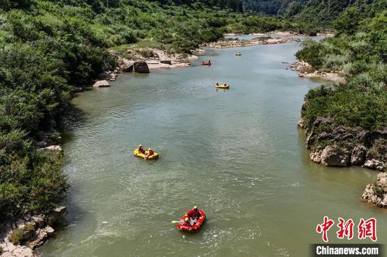 7月16日，游客在洛北河漂流享清凉。连日来，贵州持续高温天气，位于贵州省黔南布依族苗族自治州贵定县的洛北河漂流迎来高峰，不少游客来此漂流享清凉。（无人机照片）中新社记者 瞿宏伦 摄