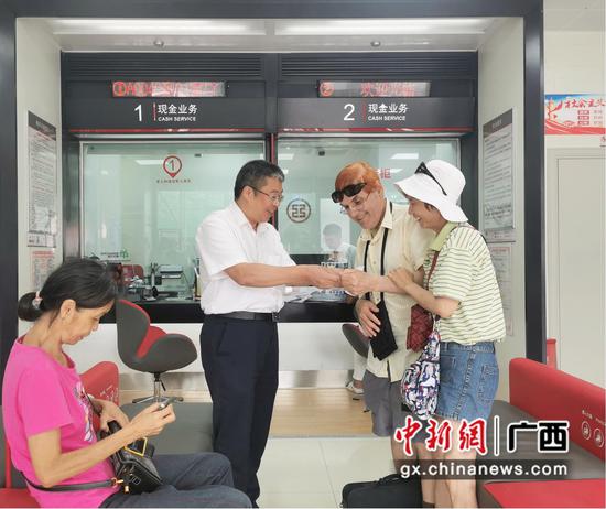 图为工行河池巴马支行耐心指导外籍夫妇办理ATM外卡取现业务。工行广西分行 供图