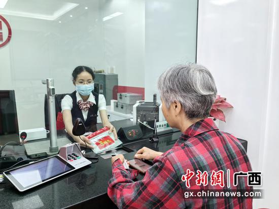 图为工行玉林解放路支行为到店老年客户办理“零钱包”兑换业务。工行广西分行供图