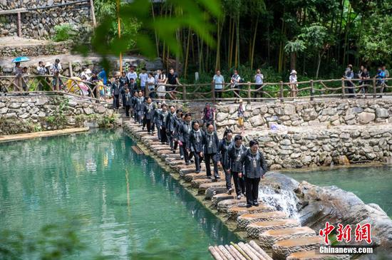 图为在贵州省从江县加榜乡下尧壮寨,壮族同胞走在拦河坝上。 图为在贵州省从江县加榜乡下尧壮寨,壮族同胞走在拦河坝上。