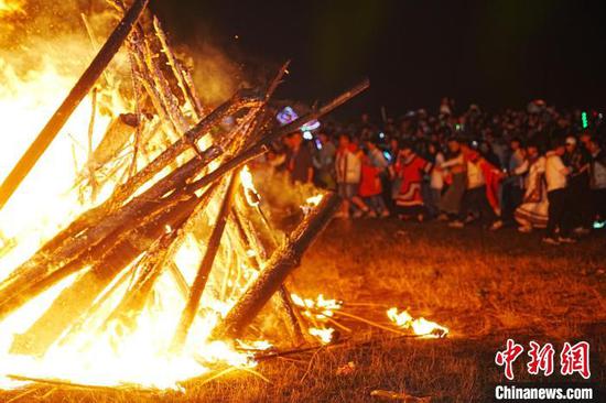 图为游客围着篝火跳舞。赵园摄 图为游客围着篝火跳舞。赵园摄
