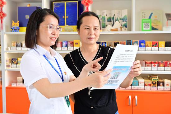 来宾烟草工作人员(左一)为零售客户讲解“清廉监督卡”。 来宾烟草工作人员(左一)为零售客户讲解“清廉监督卡”。