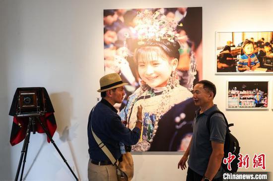 7月30日,日本摄影师稻垣德文(左)在给参观者介绍他的入展作品。记者 瞿宏伦 摄 7月30日,日本摄影师稻垣德文(左)在给参观者介绍他的入展作品。记者 瞿宏伦 摄
