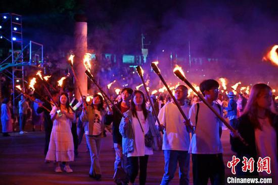 8月2日晚，贵州六盘水海坪彝族风情小镇火把广场的火把节活动吸引游客参加。2024年海坪彝族火把季于7月13日开幕，活动持续至8月11日。本次活动围绕取火、送火的火把节传统文化核心，展现彝族文化的魅力，吸引游客参加。中新社记者 陈楚红 摄