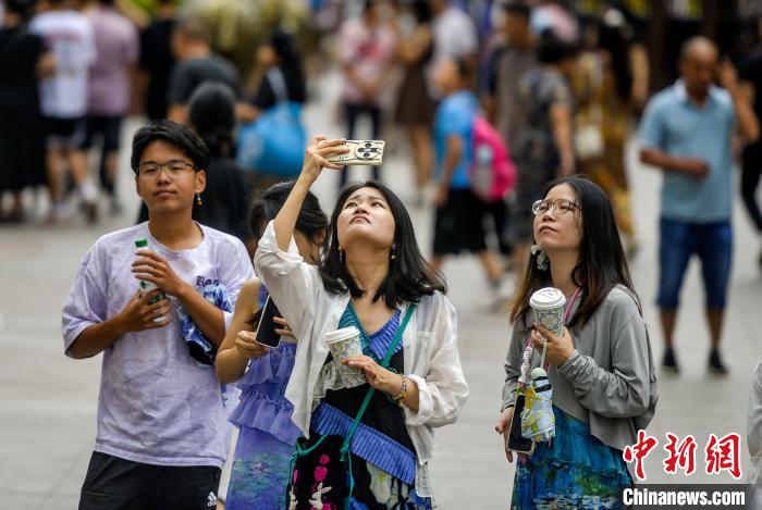 8月7日，位于烏魯木齊市的新疆國(guó)際大巴扎景區(qū)，游客用手機(jī)拍攝觀光塔。進(jìn)入8月，新疆各地豐富的自然和人文旅游資源，吸引游客紛至沓來(lái)，各大景區(qū)景點(diǎn)游客數(shù)量不斷攀升，陸續(xù)迎來(lái)暑期旅游高峰。中新社記者 劉新 攝