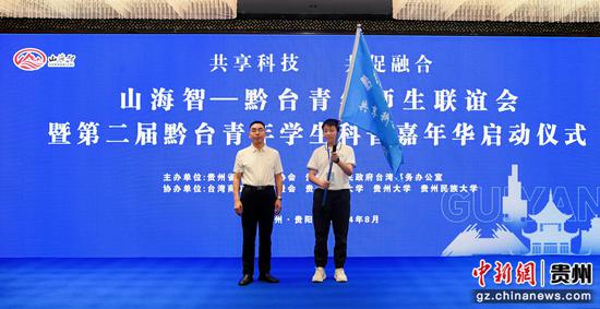 贵州省人民政府台湾事务办公室副主任李伟刿(左)为活动授旗。贾智 摄