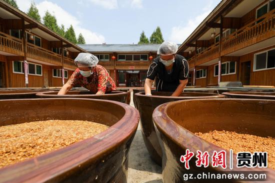 2024年8月29日,村民在贵州省铜仁市江口县民和镇艾坪村一家古法酱油加工厂翻晒黄豆酱料。李鹤摄 2024年8月29日,村民在贵州省铜仁市江口县民和镇艾坪村一家古法酱油加工厂翻晒黄豆酱料。李鹤摄