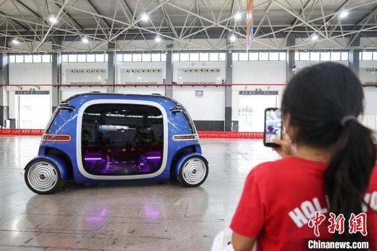 数博会期间,观众在拍摄行驶中的无人驾驶小巴。中新社记者 瞿宏伦 摄 数博会期间,观众在拍摄行驶中的无人驾驶小巴。中新社记者 瞿宏伦 摄