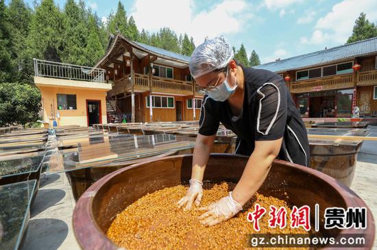 2024年8月29日,村民在贵州省铜仁市江口县民和镇艾坪村一家古法酱油加工厂翻晒黄豆酱料。李鹤摄 2024年8月29日,村民在贵州省铜仁市江口县民和镇艾坪村一家古法酱油加工厂翻晒黄豆酱料。李鹤摄