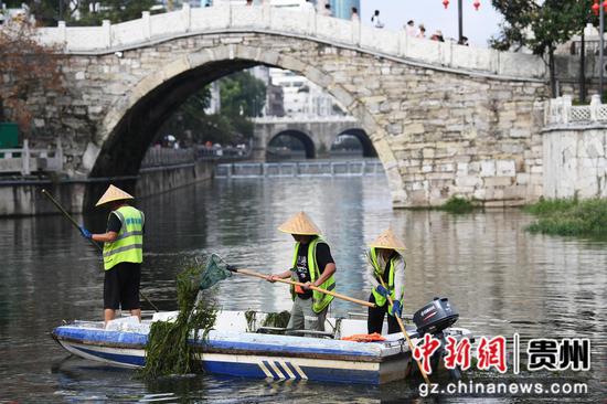 9月12日，贵阳市河湖保护中心的河道疏捞工人正在甲秀楼河段清理水草及水体漂浮物。