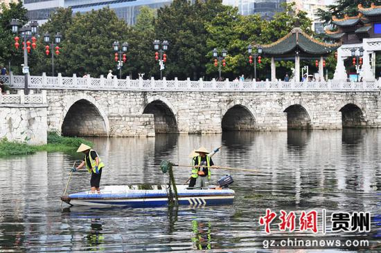 9月12日，贵阳市河湖保护中心的河道疏捞工人正在甲秀楼河段清理水草及水体漂浮物。