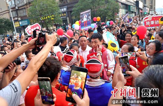 2024年9月11日，在巴黎残奥会勇夺三金的贵州施秉县游泳运动员杨洪回到居住小区，苗族妇女给其盖上“太阳花”祝福。奉力摄