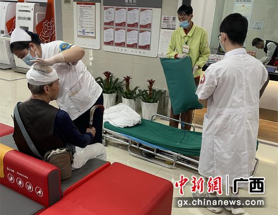 图为医护工作人员在网点为老人包扎伤口。 图为医护工作人员在网点为老人包扎伤口。