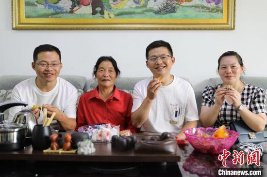 图为兄弟俩和家人吃月饼。 潘娅 摄 图为兄弟俩和家人吃月饼。 潘娅 摄
