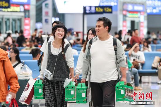 9月17日,旅客步入贵阳北站候车大厅。当日是中秋假期最后一天,位于贵阳市观山湖区的贵阳北站迎来返程客流。中新社记者瞿宏伦摄 9月17日,旅客步入贵阳北站候车大厅。当日是中秋假期最后一天,位于贵阳市观山湖区的贵阳北站迎来返程客流。中新社记者瞿宏伦摄