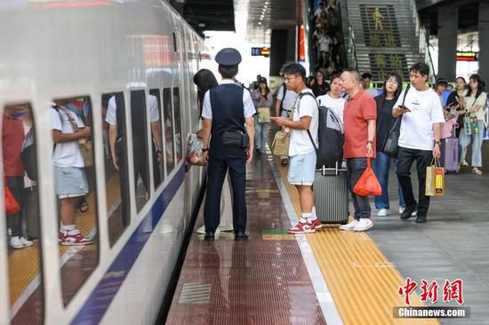 9月17日,旅客在贵阳北站月台登车。当日是中秋假期最后一天,位于贵阳市观山湖区的贵阳北站迎来返程客流。中新社记者瞿宏伦 摄 9月17日,旅客在贵阳北站月台登车。当日是中秋假期最后一天,位于贵阳市观山湖区的贵阳北站迎来返程客流。中新社记者瞿宏伦 摄