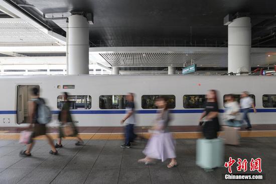 9月17日,旅客步入贵阳北站月台。当日是中秋假期最后一天,位于贵阳市观山湖区的贵阳北站迎来返程客流。中新社记者瞿宏伦 摄 9月17日,旅客步入贵阳北站月台。当日是中秋假期最后一天,位于贵阳市观山湖区的贵阳北站迎来返程客流。中新社记者瞿宏伦 摄