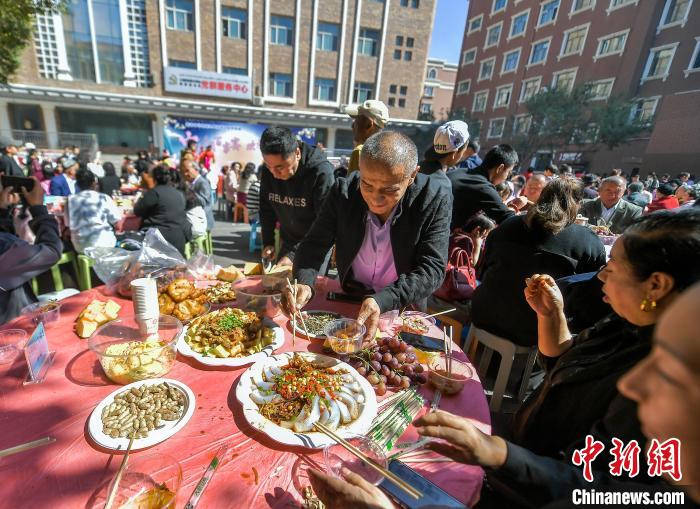 9月15日，新疆烏魯木齊市天山區(qū)固原巷社區(qū)舉辦“中秋月圓百家宴”活動(dòng)，轄區(qū)居民端來(lái)自家制作的美食，圍坐在一起品嘗佳肴，共敘佳話，迎接中秋佳節(jié)到來(lái)。中新社記者 劉新 攝