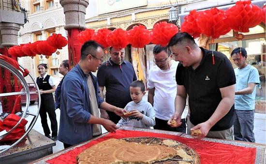 工作人員為市民、游客分月餅。