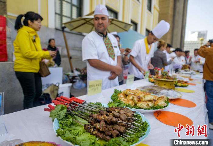 9月18日，位于新疆烏魯木齊市南門的新疆人民劇場門前，一場美食廚藝大賽在此舉辦，吸引眾多過往市民駐足圍觀。 中新社記者 劉新 攝