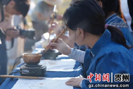 布依族枫香染传承人和爱好者在土布上画丰收。 布依族枫香染传承人和爱好者在土布上画丰收。