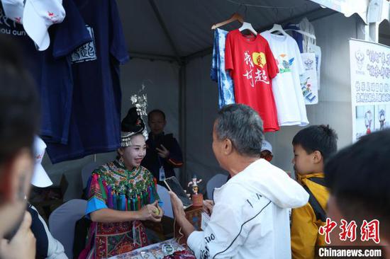 图为贵州“村超”拉拉队员熊竹青在“乡村振兴足球文化嘉年华”上推荐“村超”文创产品。记者 蒋启明 摄 图为贵州“村超”拉拉队员熊竹青在“乡村振兴足球文化嘉年华”上推荐“村超”文创产品。记者 蒋启明 摄