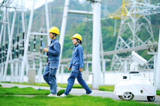 在铜仁市500千伏变电站,5G智能机器人和运维人员正在对变电站内主要供电设备开展巡视工作。陈涛、陈厦华 摄 在铜仁市500千伏变电站,5G智能机器人和运维人员正在对变电站内主要供电设备开展巡视工作。陈涛、陈厦华 摄