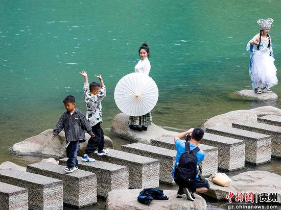 游客在贵州省黔南布依族苗族自治州罗甸县大小井风景名胜区游玩拍照。