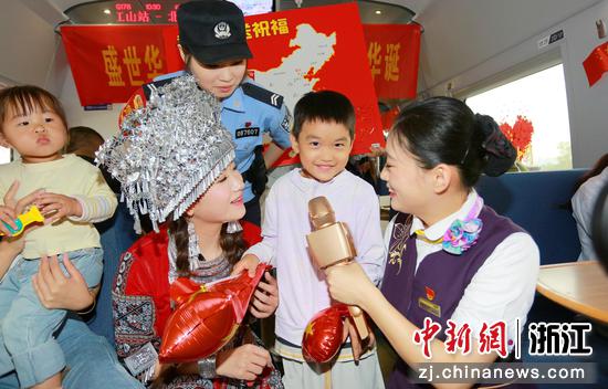 图为:铁路民警、乘务人员等和乘客互动。中新社发 贺瑞明 摄