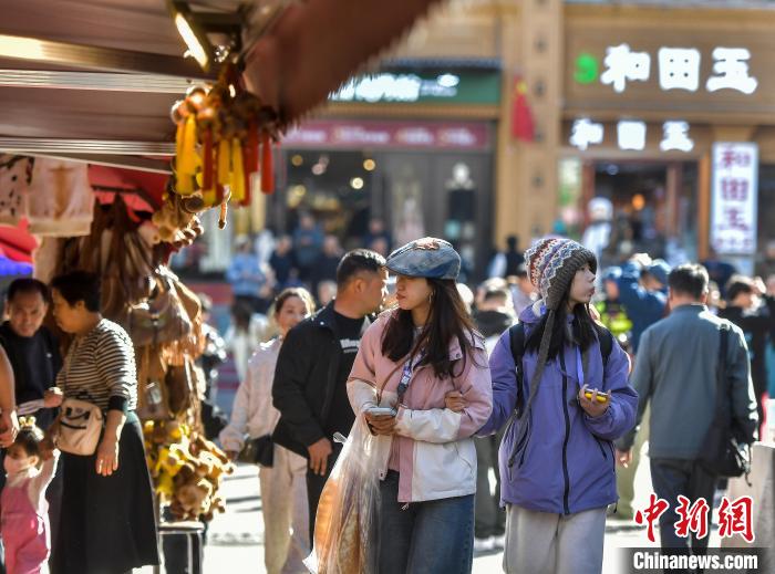 10月1日，國慶假期首日，新疆烏魯木齊大巴扎步行街游人如織，各地游客在此觀光、游覽、購物。進入秋季，烏魯木齊大巴扎步行街熱度依然不減，連日來日均客流量達10萬人次以上。中新社記者 劉新 攝