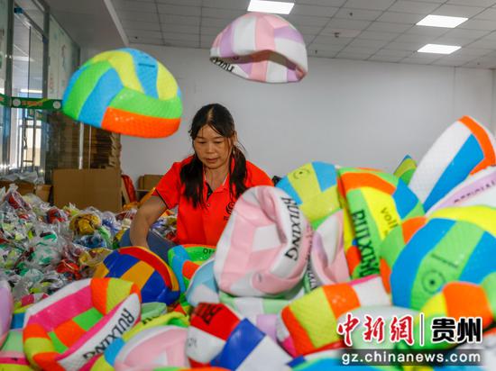 2024年10月8日，工人在贵州省黔南布依族苗族自治州罗甸县工业园区一家足球生产企业分拣足球。