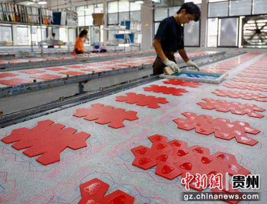 2024年10月8日，工人在贵州省黔南布依族苗族自治州罗甸县工业园区一家足球生产企业加工生产足球的材料。